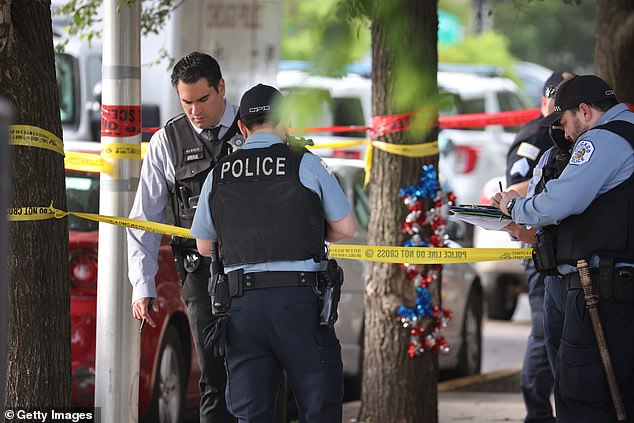 Shootings are up 18 percent in Chicago. Police in the city are pictured at the scene of a homicide last week